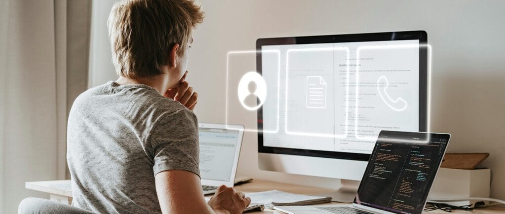 A man sitting in front of a computer, thinking how to best implement data standards as part of his conference data hygiene strategy.