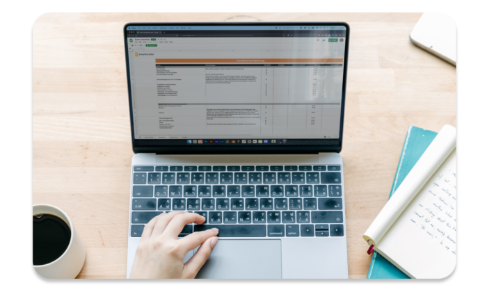 Eventplaner*in arbeitet am Laptop mit der großen Eventplanungs-Checkliste.