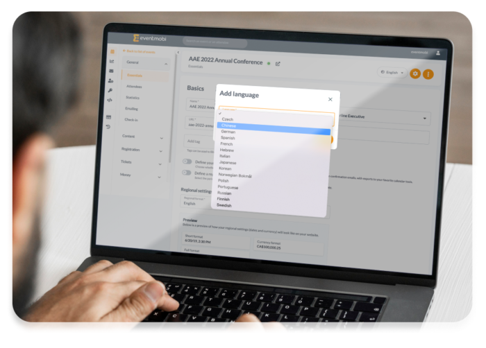 A man using his laptop to check the available languages from the backend of the registration website.